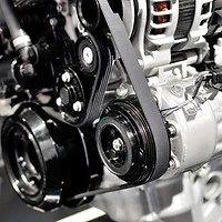 Air conditioning compressor and drive belt in an engine bay