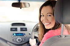 Mobile car aircon regas | atmechanical | Perth Smiling woman seated in a car with dashboard air conditioning controls | atmechanical | Perth