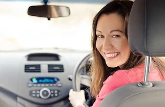 Mobile car aircon regas | atmechanical | Perth Smiling woman seated in a car with dashboard air conditioning controls | atmechanical | Perth